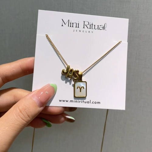 Gold zodiac shell charm with white shell inlay and zircon accents in 18K gold plated stainless steel