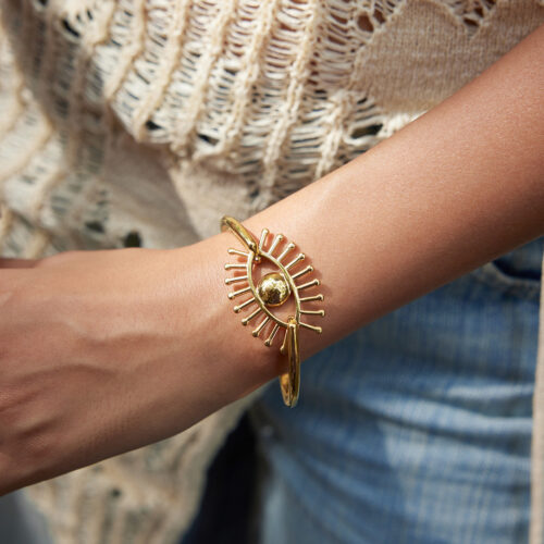 Gold evil eye bracelet with a radiant sunburst design in gold-tone stainless steel