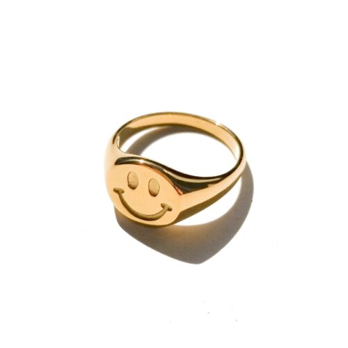 Gold smiley face signet ring with a chunky polished stainless steel band
