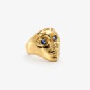 Gold face ring with blue zirconia eyes and a sculptural gold-tone design