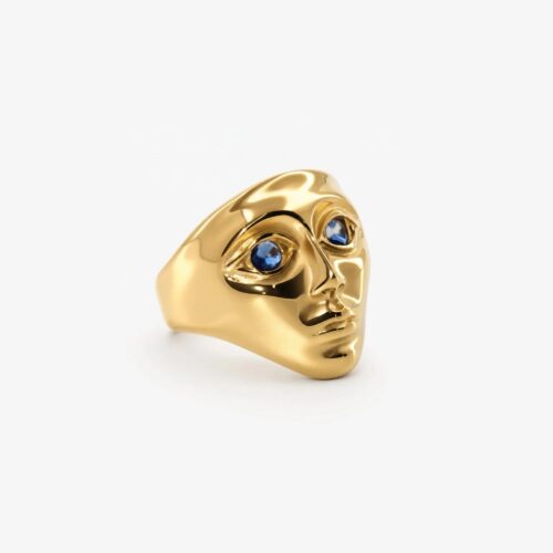 Gold face ring with blue zirconia eyes and a sculptural gold-tone design